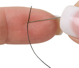 Fingers threading a needle